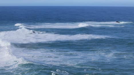 slow cinematic drone movement over vibrant blue waves crashing