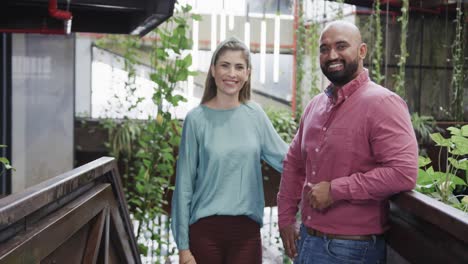 two happy diverse creative designers in discussion in casual office, slow motion