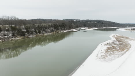 flying over the tranquil waters of river in daytime during winter in arkansas, usa