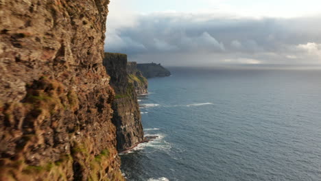 Los-Delanteros-Vuelan-Alrededor-De-La-Pared-De-Roca.-Revelando-Hermosos-Paisajes-De-Altos-Acantilados-Verticales-En-La-Costa-Del-Mar.-Acantilados-De-Moher,-Irlanda