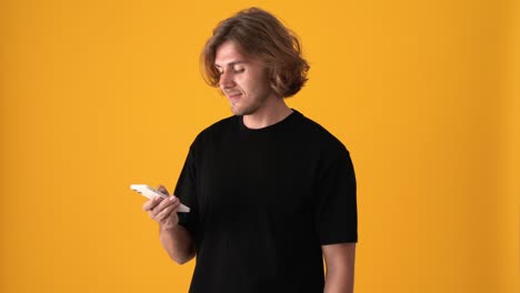 pensive blond man texting by phone