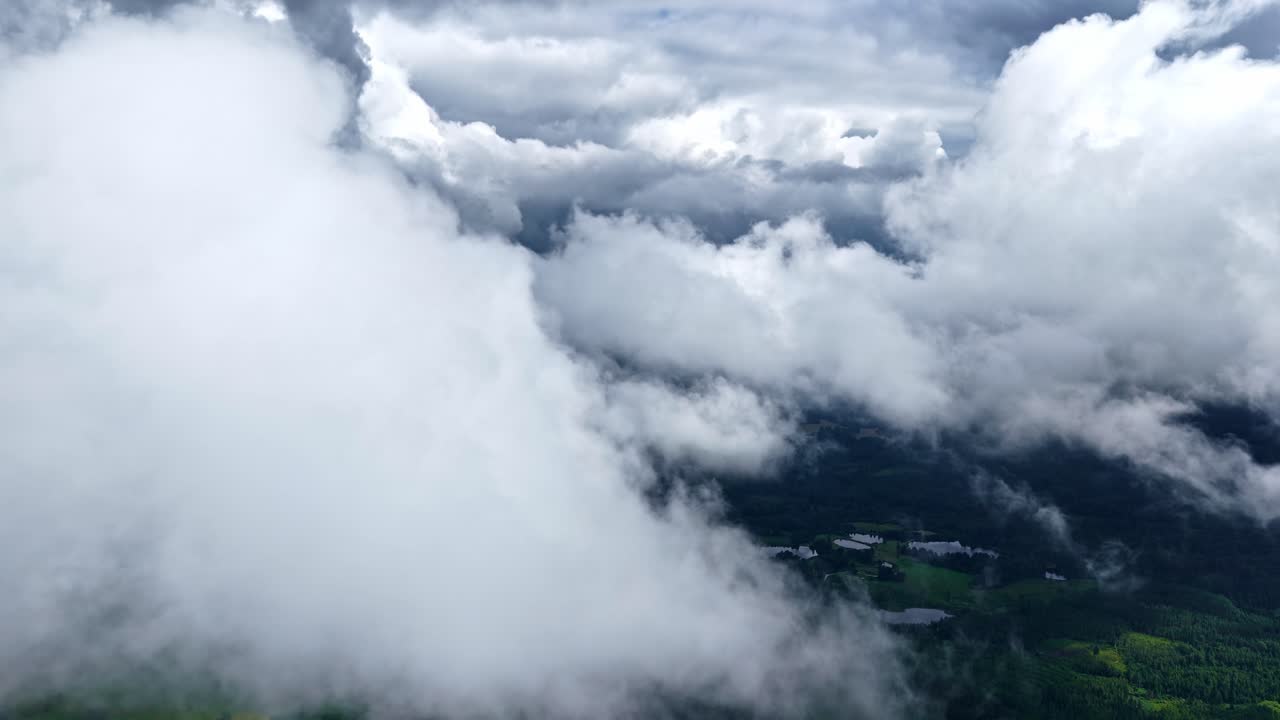 Breathtaking freedom of flight in an immersive aerial journey, soaring between and through majestic, towering clouds high above a distant forested landscape