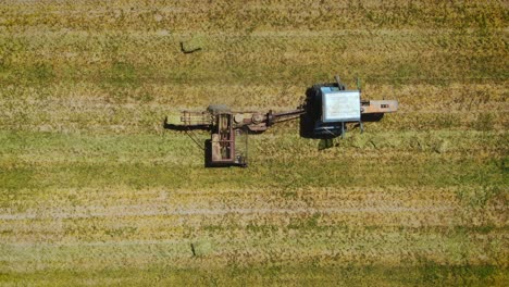 vista superior de una máquina empacadora de heno en tierras de cultivo de cáñamo en almaty, kazajstán