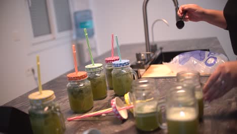 young latin girl prepare cocktail mocktail or smoothie at her kitchen