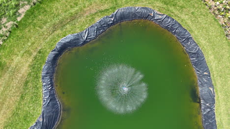 Reservoir---Artificial-Lake,-water-reserve-for-agriculture,-farming-and-fish-reproduction,-man-made-lake-with-a-water-pump-in-the-middle,-top-down-aerial-view