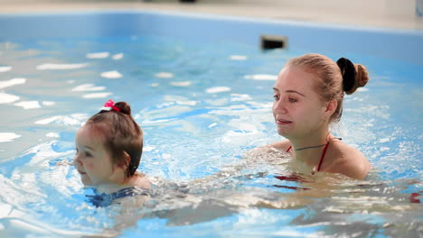 cute baby boy enjoying with his mother in the pool.