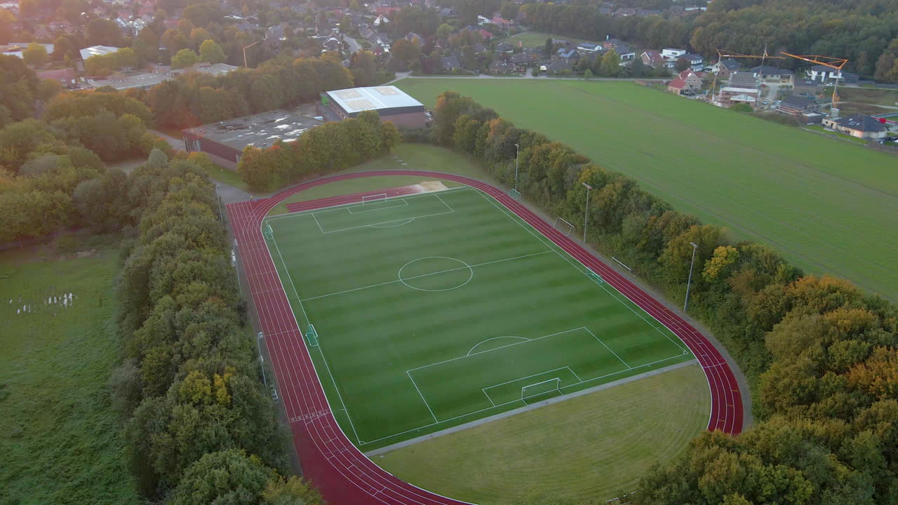 Football Stadium Surrounded With Lush Green Forest In Sogel, Lower Saxony, Germany. aerial