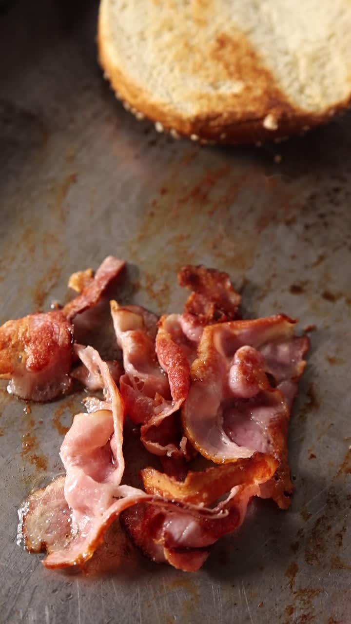 Pancetta che sfrigola su una piastra calda con un panino tostato