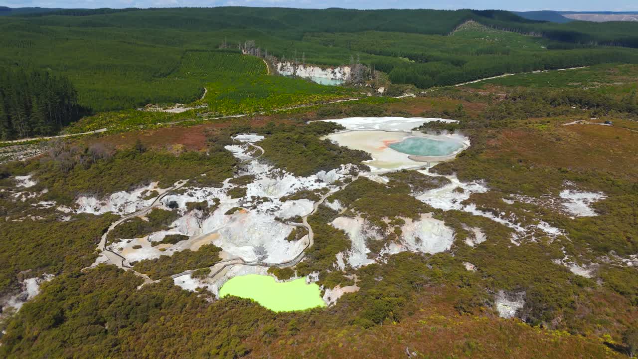 Champagne Pool e Devil’s Bath brilham no paraíso termal de Waiotapu perto da Rotorua geotérmica, tomada aérea com drone em órbita ampla à direita.