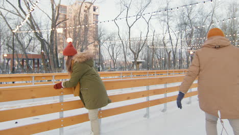 couple ice skating in winter park