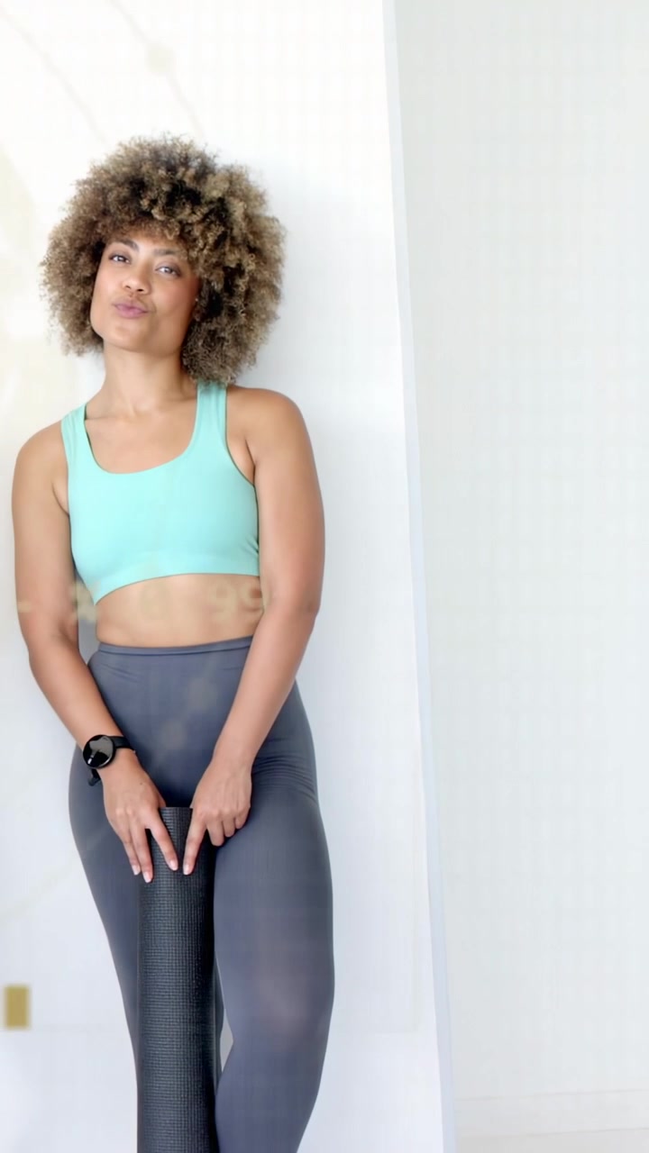 Video verticale: Donna che tiene un rullo, guarda e aggiusta la presa, lanciando un HUD con dati fitness dorati.