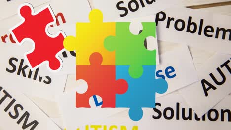 animation of colourful puzzle pieces, autism awareness month text