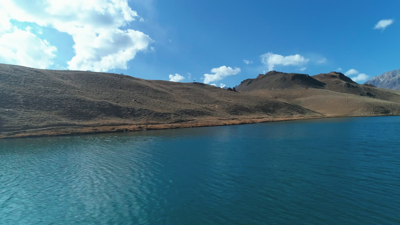 poderosa vista aérea de un hermoso y vibrante lago azul con aguas claras, rodeado de montañas