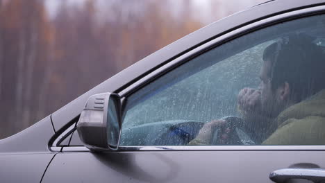 El-Hombre-Se-Sienta-Detrás-Del-Volante-Y-Piensa-En-La-Vida,-Vista-Lateral-Exterior