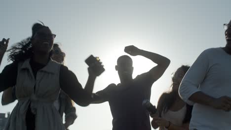 happy young people dancing with raised hands.