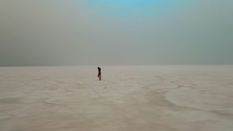 woman in swimsuit walking barefoot in bonneville salt flats in tooele county, utah