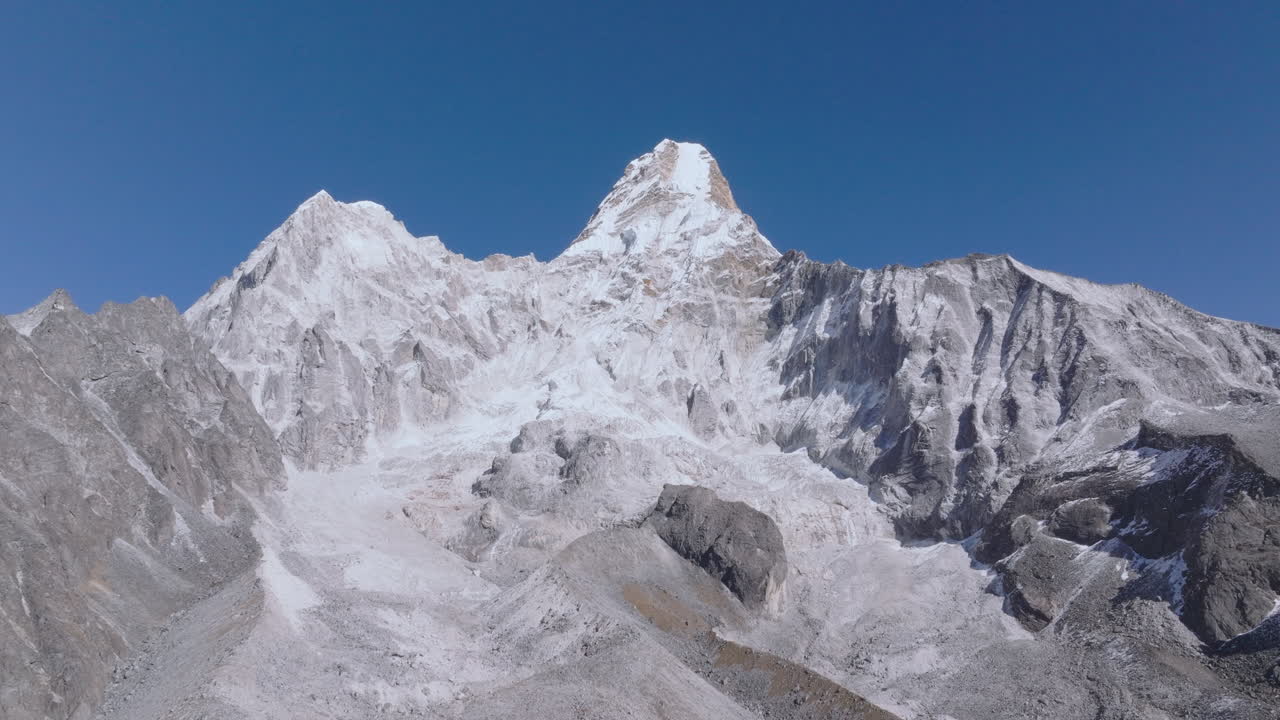 Ripresa aerea in movimento verso il monte Ama Dablam, che rivela uno splendido paesaggio himalayano da una prospettiva elevata in Nepal. Scenari alpini mozzafiato per viaggi e documentari