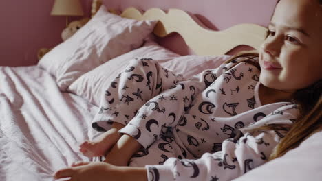 girl lying on bed in pajamas