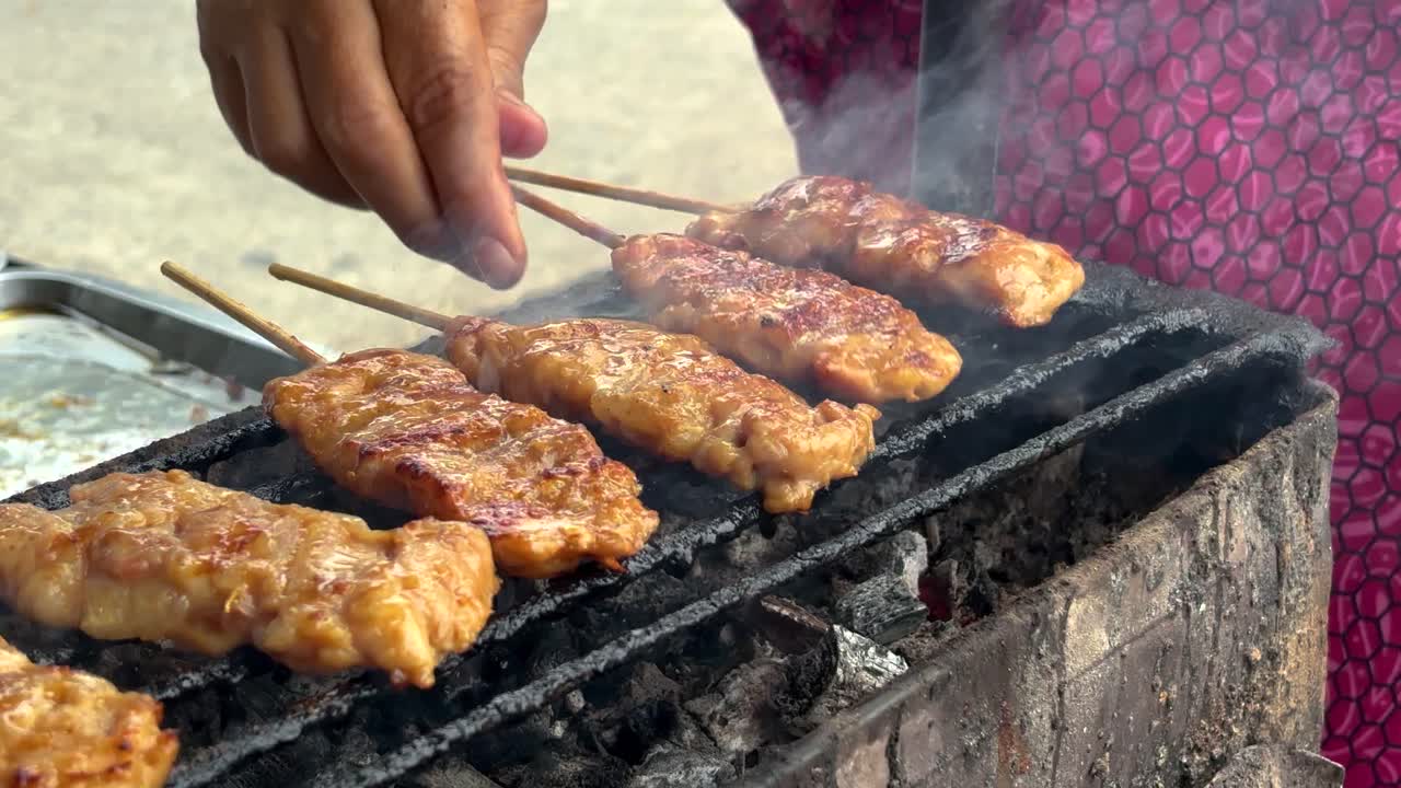 Close-up of Thai food, BBQ pork skewers on a charcoal stove in Thailand street food