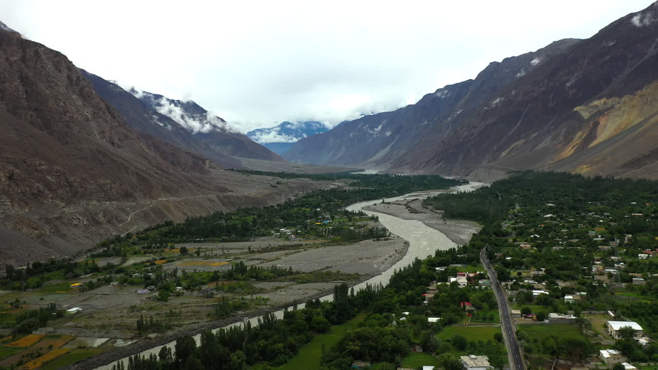 toma cinematográfica de drones de una pequeña ciudad o pueblo en el valle, conos passu en hunza pakistán, río hunza, toma aérea alta y ancha
