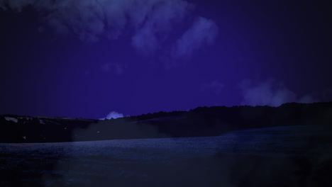 animation of white clouds moving on night sky in seamless loop over countryside landscape