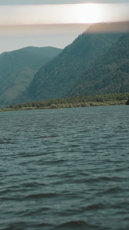 large mountains covered with wild wood on coast view from sailing yacht. gorgeous ridge observing while riding motor boat on holiday cruise