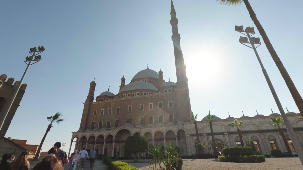 Turisti camminano verso la Grande Moschea di Muhammad Ali al Cairo