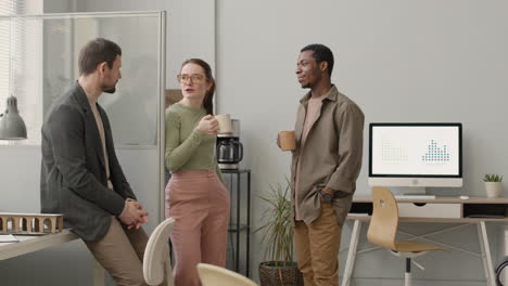 equipo de negocios multiétnico tomando café y hablando en la oficina