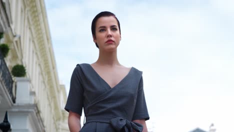 stylish woman carrying bag walks along city street