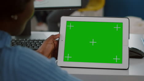 Close-up-of-african-worker-immobilized-in-wheelchair-looking-at-tablet-with-mock-up-display