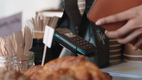 cerca del cliente pagando con tarjeta de crédito servicio de pago sin contacto comprando café en un café gastando dinero en un restaurante