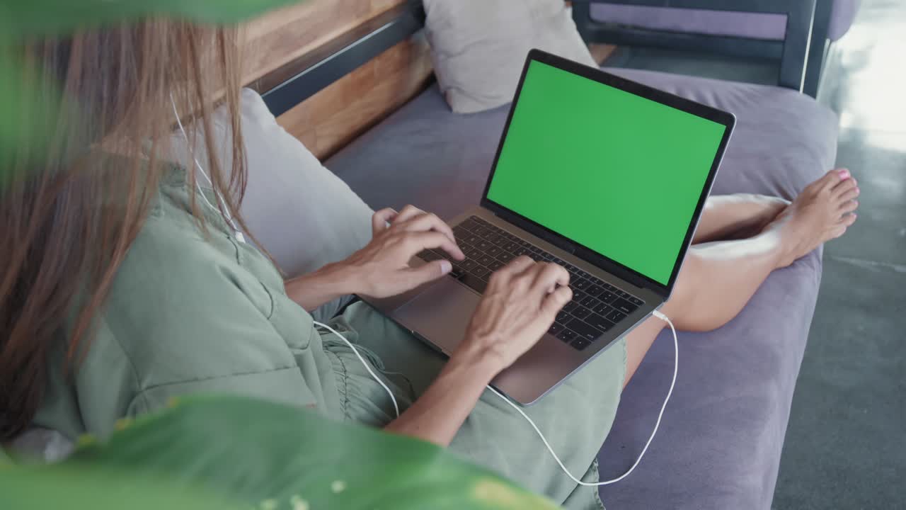 persona con una computadora portátil de pantalla verde en el sofá