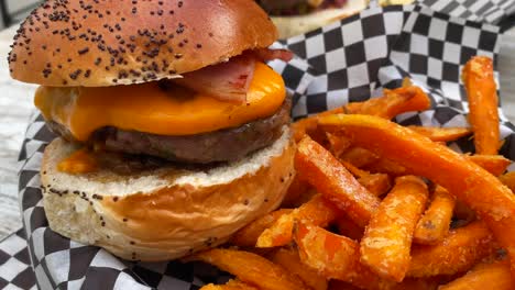 sabrosa hamburguesa con queso con tocino, un pan de brioche y patatas fritas, comida pesada no saludable, tiro de 4k