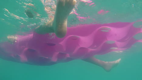 Underwater-Shooting-An-Inflatable-Mattress-Swaying-On-The-Waves-Of-The-Sea-His-Legs-Are-Hanging-From