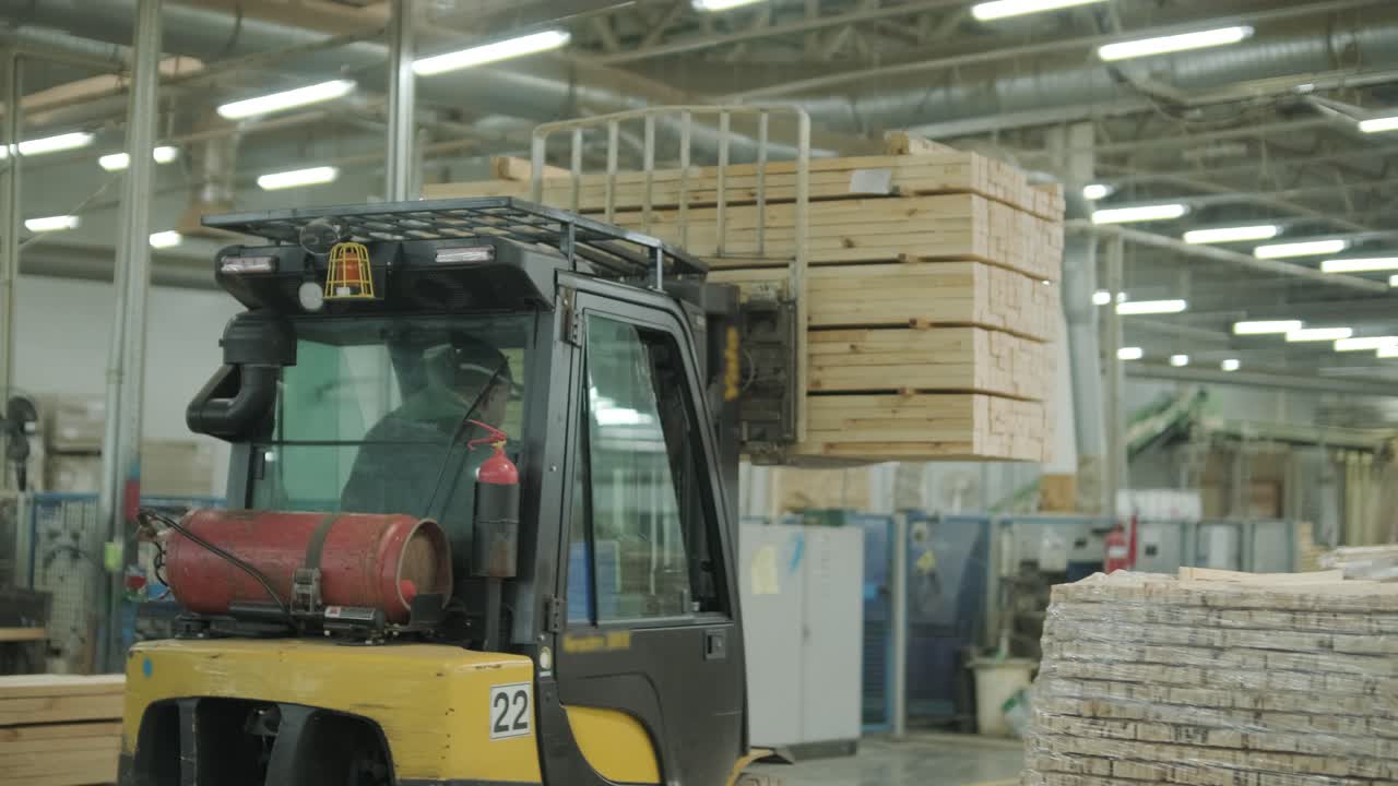 Forklift Transporting Stacked Lumber in a Woodworking Factory