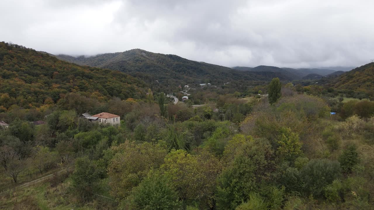 vista aérea de las montañas pueblo camino de campo en hermosos prados verdes montañas valle