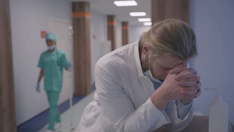 a young doctor with long, blond hair is very stressed out after a difficult day of bad news