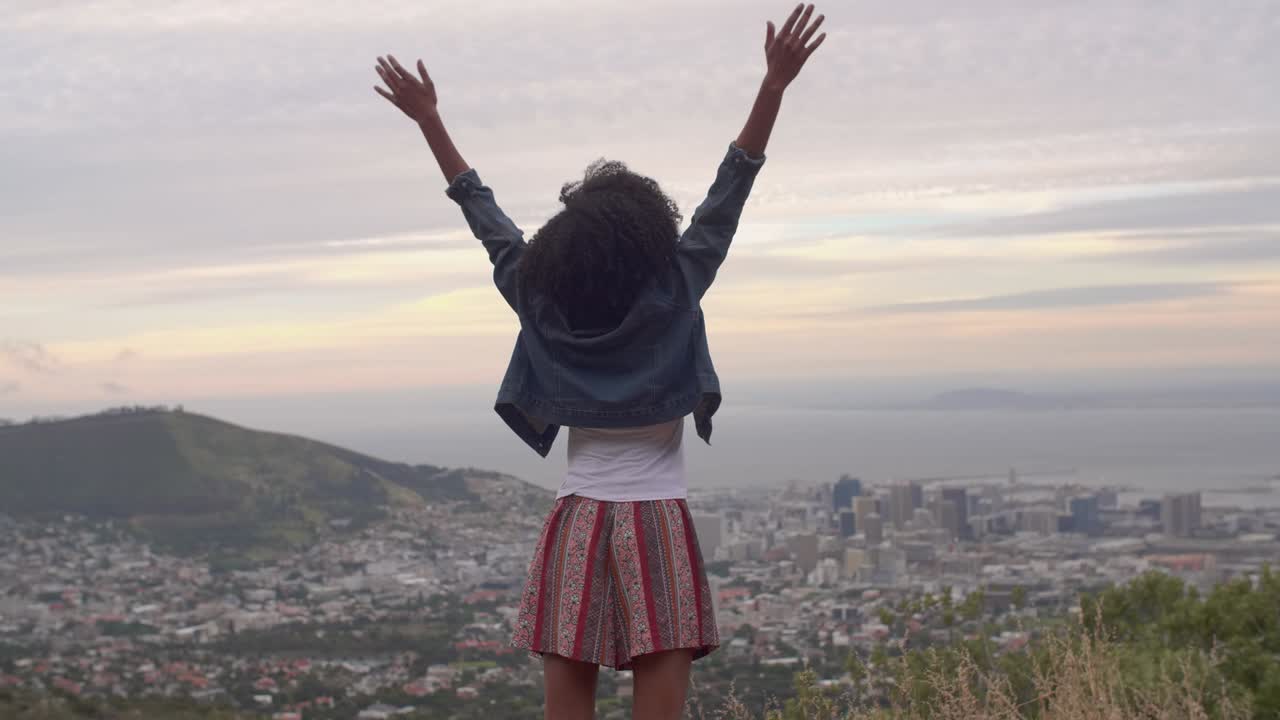 mujer afroamericana con vistas a la ciudad de abajo