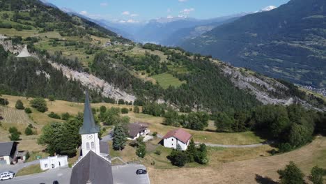 Idyllische-Kirche-In-Grüner-Berglandschaft-Im-Wallis-In-Der-Schweiz,-Perfektes-Sonniges-Wetter