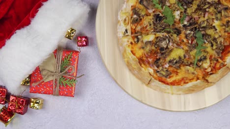 flat lay of pizza spinning 360 degree rotation on wooden salver, christmas decorations around