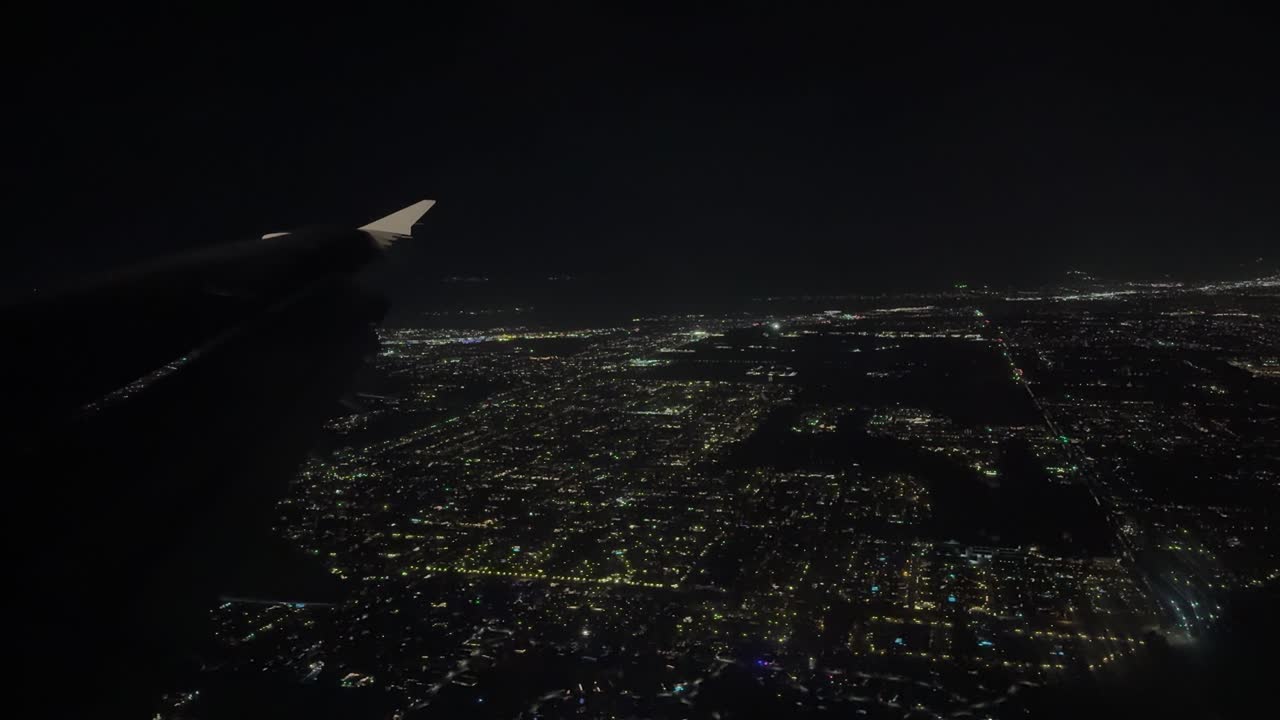 City lights seen at night from an airplane window during American Airlines flight