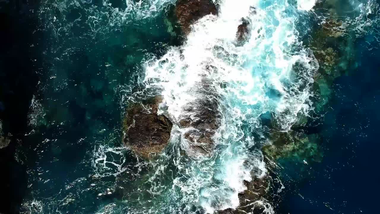 Aeriel drone footage at Garachico - Caleton (Tenerife) next to the blue ocean as the waves hit the rocks in the water