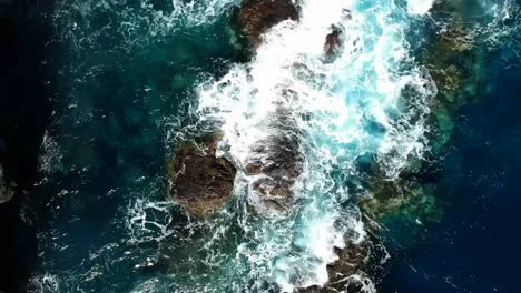 aeriel drone footage at garachico - caleton (tenerife) next to the blue ocean as the waves hit the rocks in the water