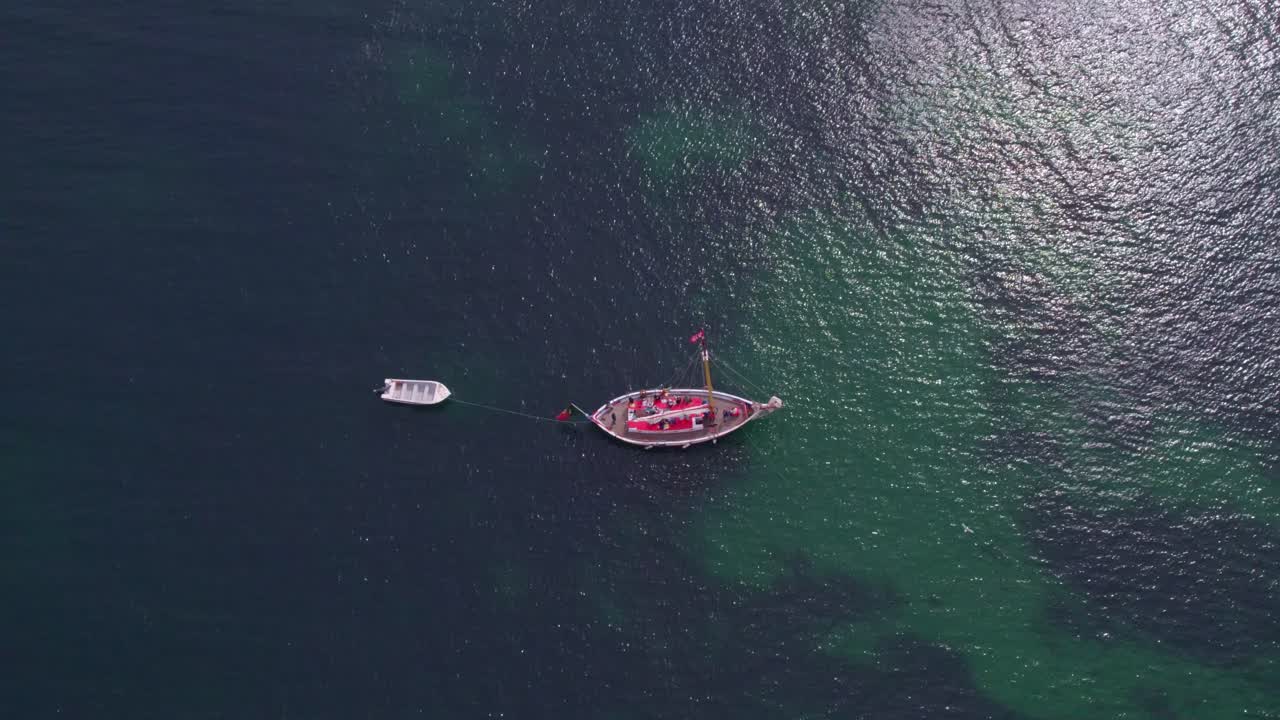 toma de arriba hacia abajo de un velero anclado en un océano tranquilo cerca de ponta da piedade portugal, aérea