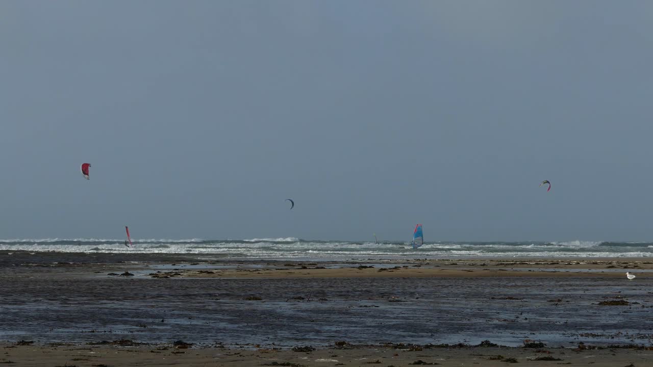 windsurfistas en la playa de rhosneigr en anglesey, gales del norte, reino unido