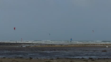 Windsurfistas-En-La-Playa-De-Rhosneigr-En-Anglesey,-Gales-Del-Norte,-Reino-Unido