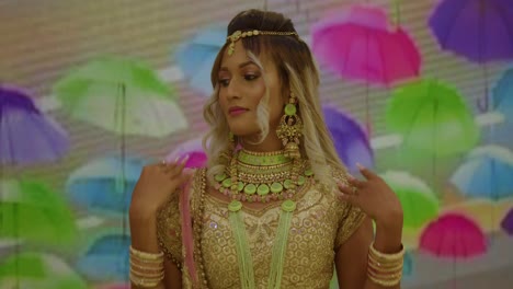 east indian girl holding bangles to her face in a traditional indian wear outfit