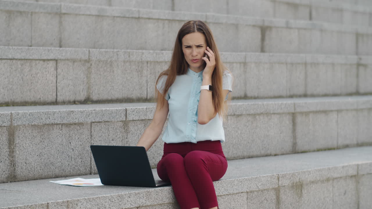 Businesswoman talking on smartphone at street. Woman using mobile phone outside