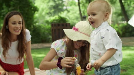 happy mother looking at kids in park.mother with children spending time together