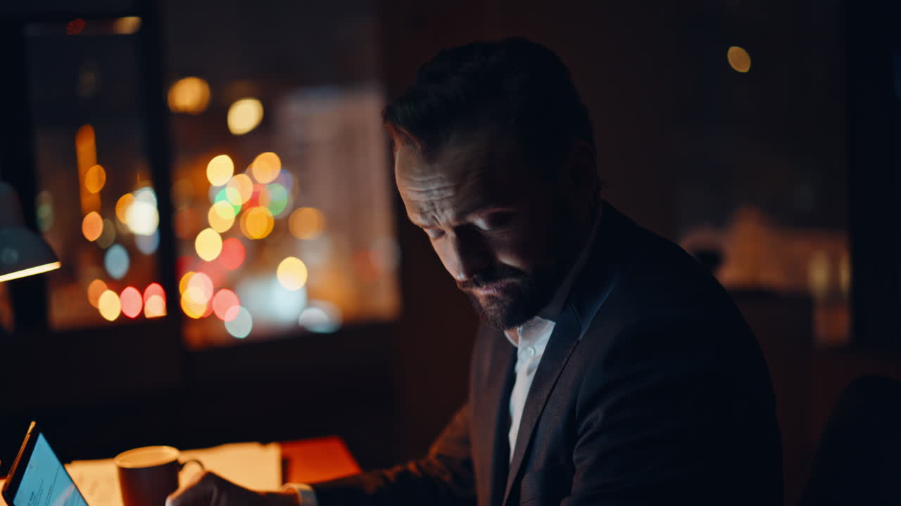 Mani del regista che digitano al computer di notte mentre cerca su Internet, primo piano. Manager che sbadiglia
